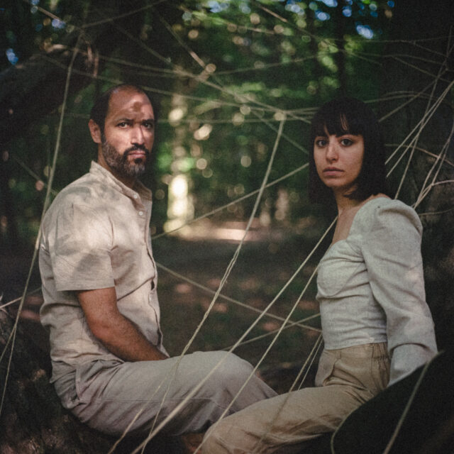 Duo indie folk Jawhar et Aza dans une forêt, regardant la caméra en pleine nature